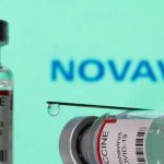 Featured & Cover Illustration shows vials labelled VACCINE Coronavirus COVID 19 and a syringe in front of a displayed Novavax logo