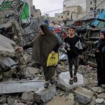 Featured & Cover Palestinians walk amid debris of buildings that were hit in Israeli airstrikes in Gaza City