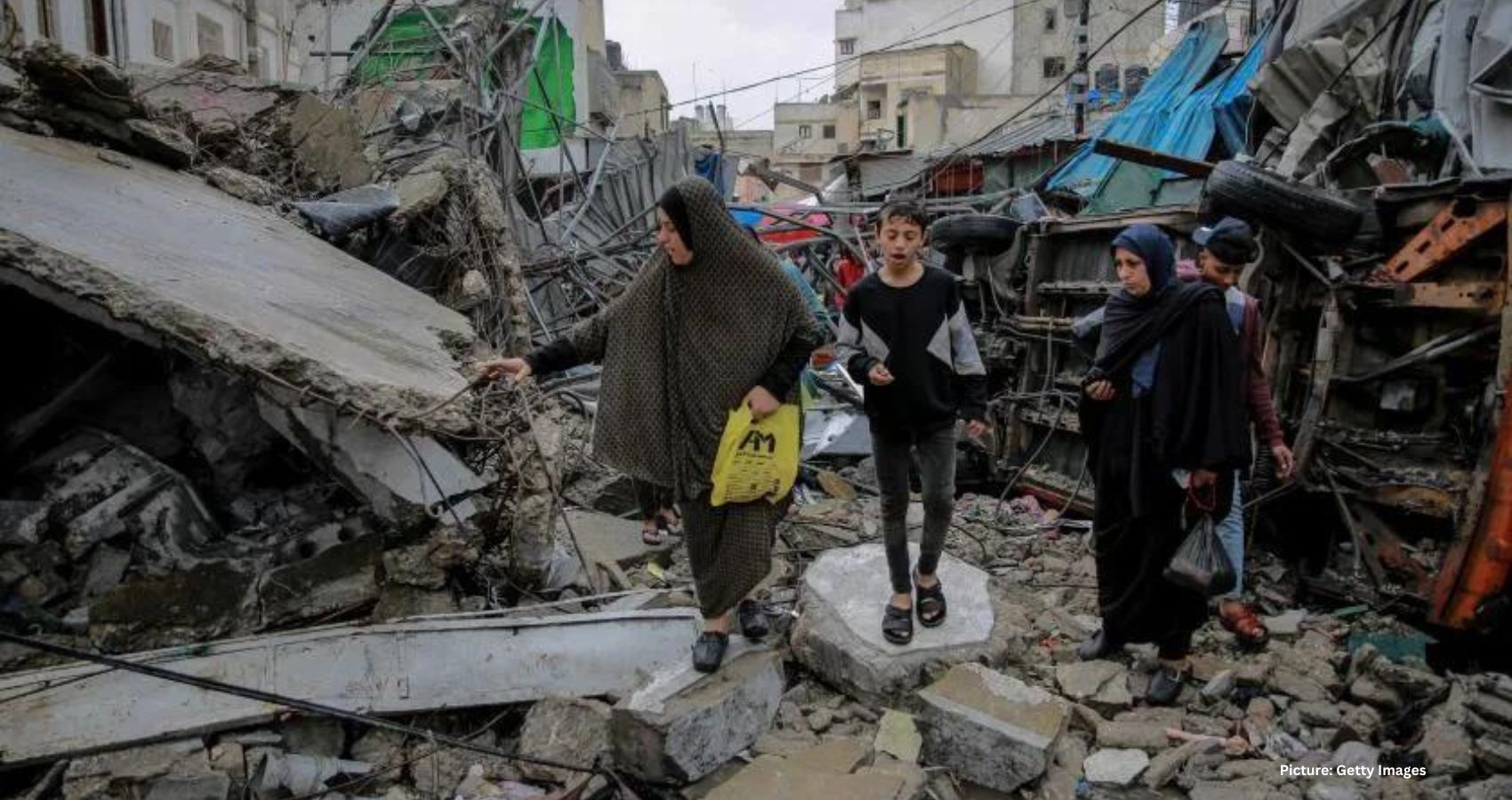 Featured & Cover Palestinians walk amid debris of buildings that were hit in Israeli airstrikes in Gaza City