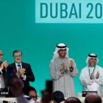 Featured & Cover COP28 president Sultan Ahmed Al Jaber (center) applauds during a plenary sessions the United Nations climate summit in Dubai on December 13 2023